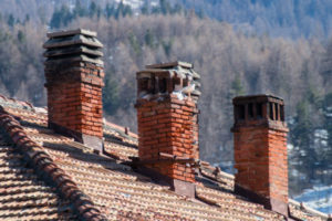 three brick chimneys on a roof